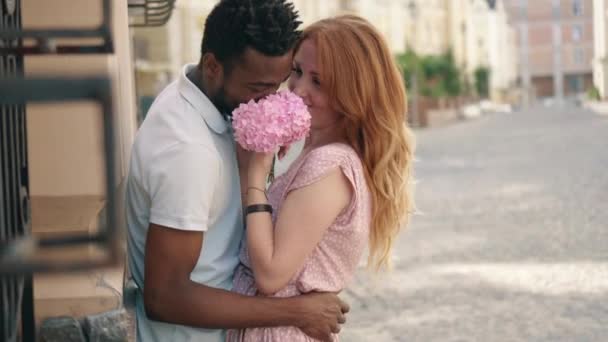 Feliz pareja joven en el amor abrazos en la calle en la ciudad en un día de verano — Vídeo de stock