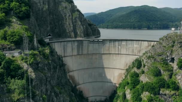 Dağlarda ormanla kaplı bir hidroelektrik barajın havadan görünüşü — Stok video