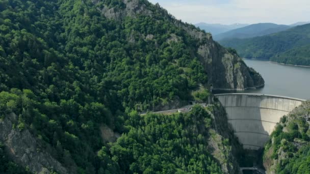 Vista aérea de uma barragem hidrelétrica nas montanhas cobertas de floresta — Vídeo de Stock