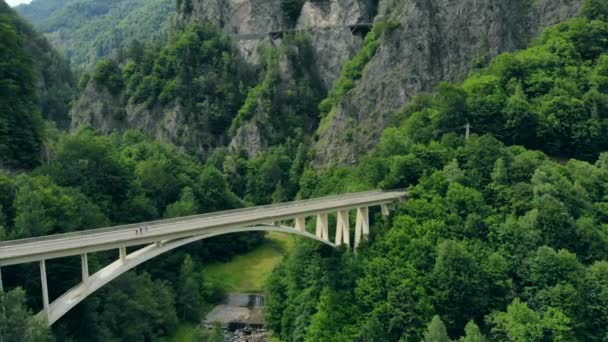 Vista aérea del puente arqueado que conecta una carretera de montaña en los Cárpatos rumanos — Vídeos de Stock