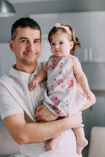 Joven padre tiene en las manos hija pequeña en casa, primer plano —  Fotos de Stock