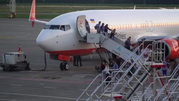 Borispol, Ukrajina - červen 2019: Cestující osobního letadla opouštějí kabinu podél rampy — Stock video