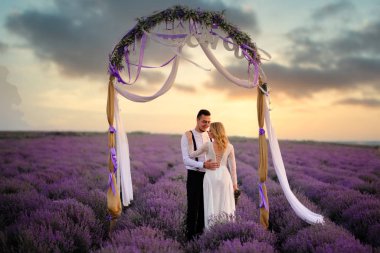 Çiçekli lavanta alanında genç mutlu gelin ve damat sarılmak