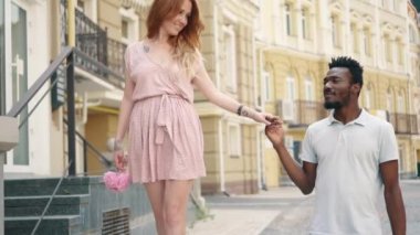 Romantik çift güneşli bir günde şehirde dolaşıyor.