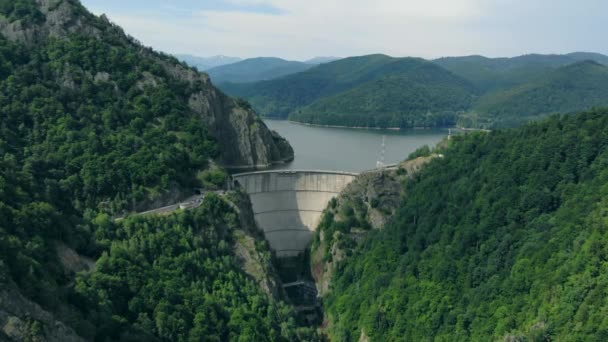 Vista aérea de uma barragem hidrelétrica nas montanhas cobertas de floresta — Vídeo de Stock