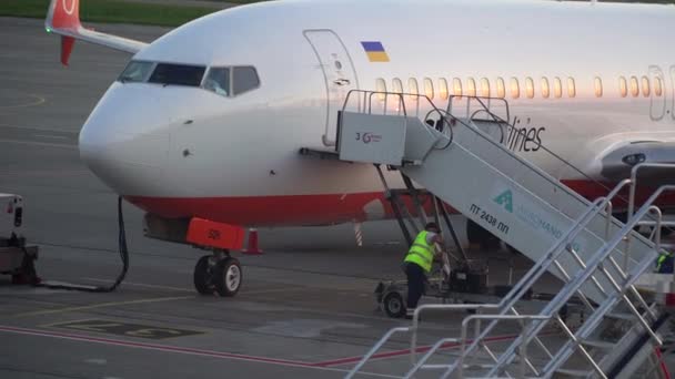 Borispol, Ukraina - czerwiec 2019: Technicy rampa lotniska łączy się z drzwiami wylądował samolot pasażerski — Wideo stockowe