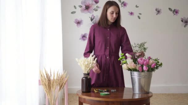 Жінка-флорист робить букет квітів у майстерні — стокове відео
