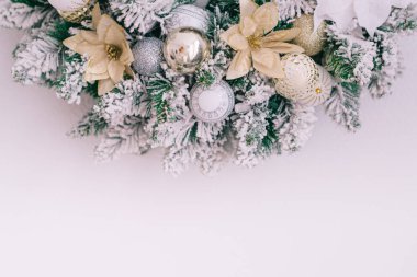 Beyaz bir duvarda karlı bir Noel çelengi. Yazmak için yeri var. Kapat.