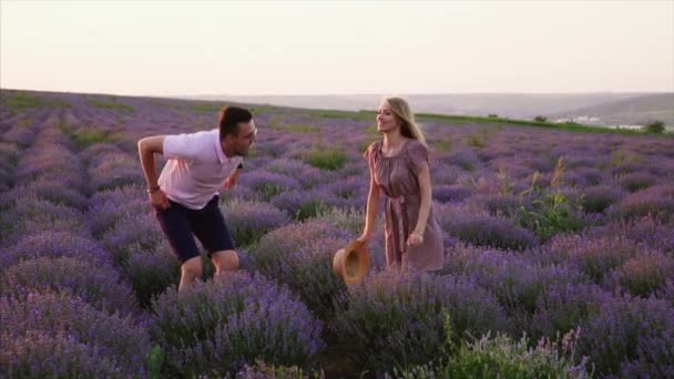 Pareja feliz saltando en un exuberante campo de lavanda . — Vídeo de stock