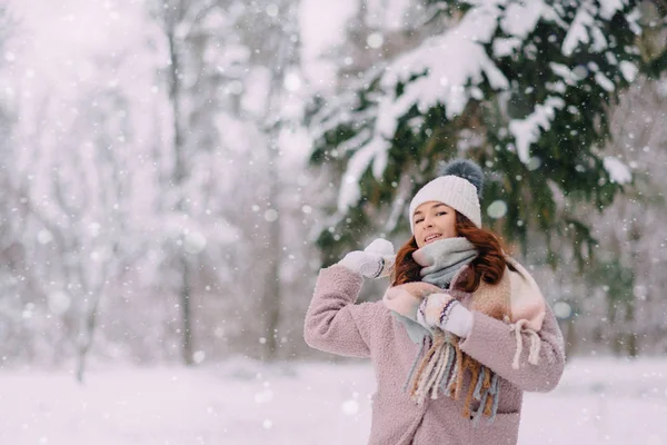 Feliz hembra lanza bolas de nieve en el parque, día de invierno —  Fotos de Stock