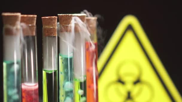 Tubos de ensaio de vidro com líquido fervente de cores diferentes no fundo do sinal de perigo biológico . — Vídeo de Stock