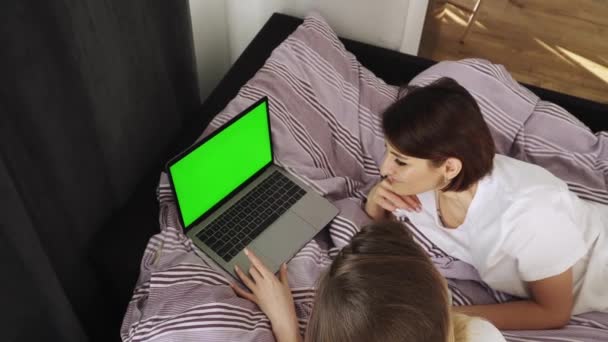 Dos mujeres felices tumbadas en la cama en casa — Vídeo de stock