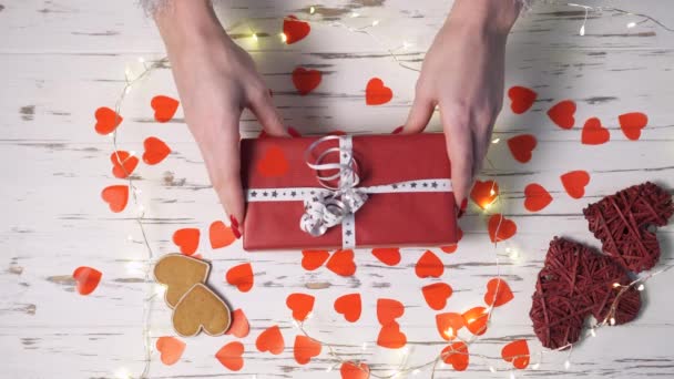 Mani femminili mettere una confezione regalo sulla scrivania, vista dall'alto verso il basso . — Video Stock