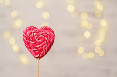 Beyaz arka planda Bokeh 'li kalp şeklinde lolipop..