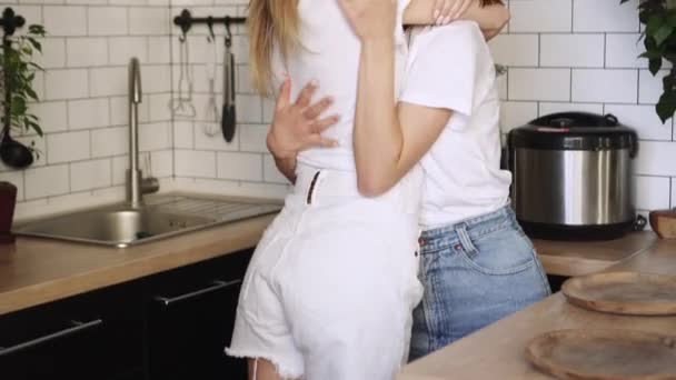 A young couple of lesbians gently cuddle at home.