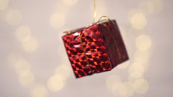 Close-up of a small gift box rotates on a blurry white background. — 비디오