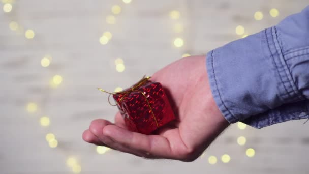 Een man geeft een vrouw een geschenk, close-up van handen. — Stockvideo