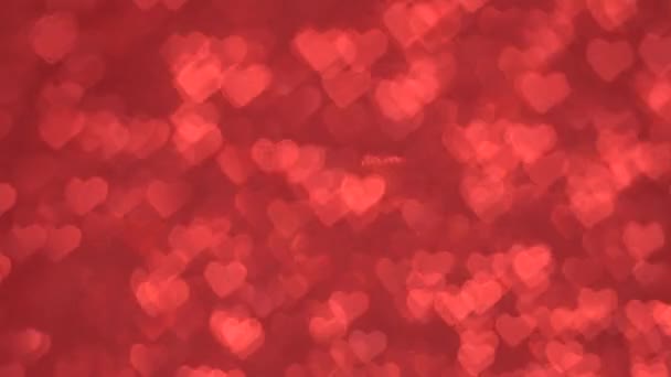 Bokeh a forma di cuore muoversi ciclicamente su uno sfondo rosso . — Video Stock