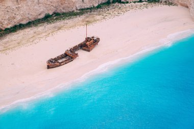 Harap olmuş eski bir gemi, deniz kıyısında uzanıyor. Yunanistan.