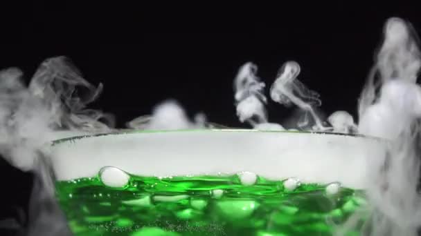 黑色底座上沸腾绿色液体中的气泡. — 图库视频影像