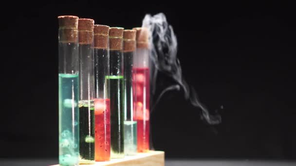 Tubos de ensayo de vidrio con líquido multicolor hirviendo . — Vídeo de stock