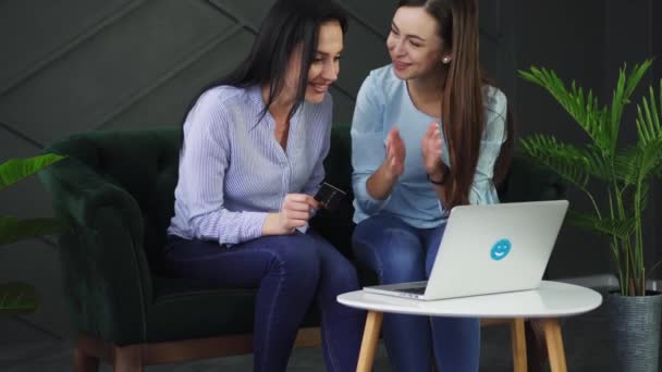 Twee vriendinnen zijn blij om tijd te hebben om goederen te kopen tegen een korting in de online winkel — Stockvideo