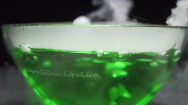 Siyah zemin üzerinde kaynayan yeşil sıvı gaz kabarcıkları.