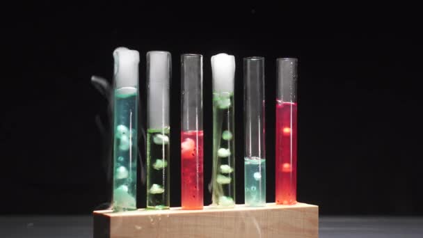 Glazen reageerbuisjes met kokende meerkleurige vloeistof. — Stockvideo