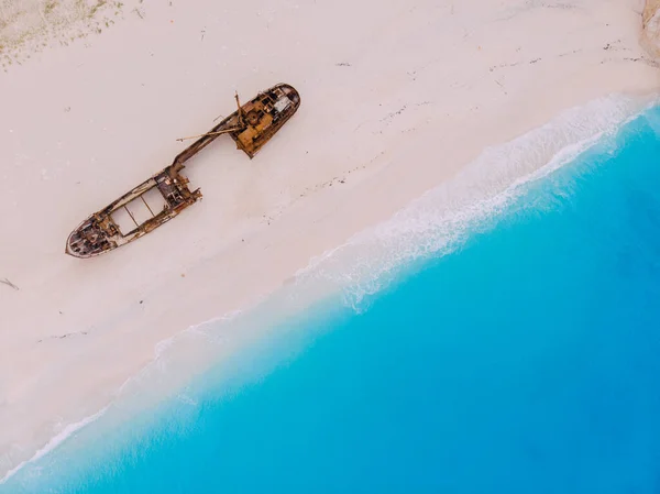 Vista superior hacia abajo en un viejo barco oxidado que yace en la playa . — Foto de Stock