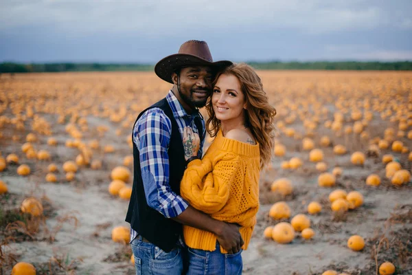 Casal fica no campo de abóbora e abraços — Fotografia de Stock