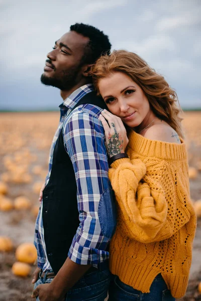 A romantic couple is standing in a pumpkin field, close-up. — Stock Photo, Image