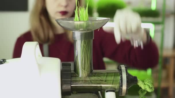 Una donna spreme il succo dal germe di grano . — Video Stock