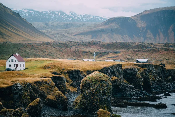 Paisagem típica islandesa com casas contra montanhas . — Fotografia de Stock