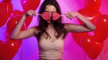 Kalp şeklinde testisleri olan neşeli kadın dans ediyor..