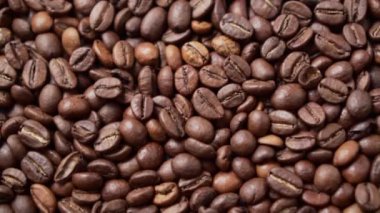 Koyu kavrulmuş kahve çekirdekleri daire şeklinde hareket eder. Kapat..