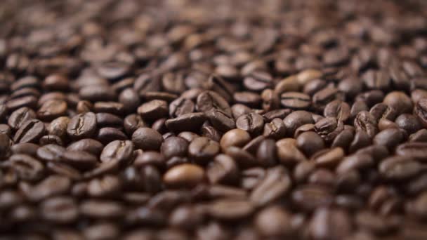 Tmavá pražená kávová zrna se pohybují v kruhu. — Stock video