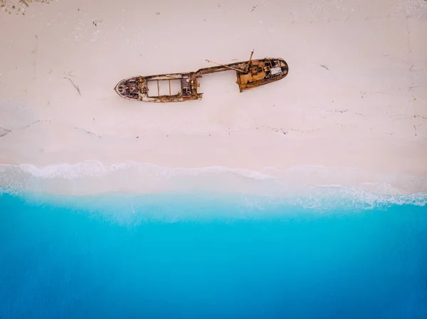 Vista superior hacia abajo en un viejo barco oxidado que yace en la playa . — Foto de Stock