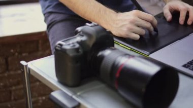 Close up of creative photographer using graphic tablet for retouching.
