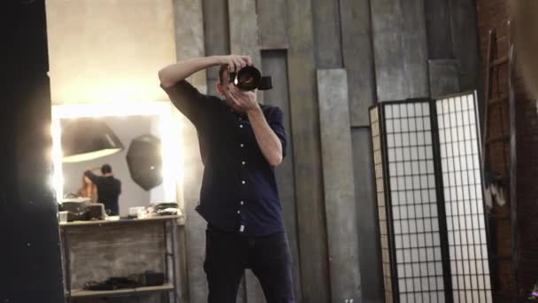 A young male photographer is photographing a model. — Stok video