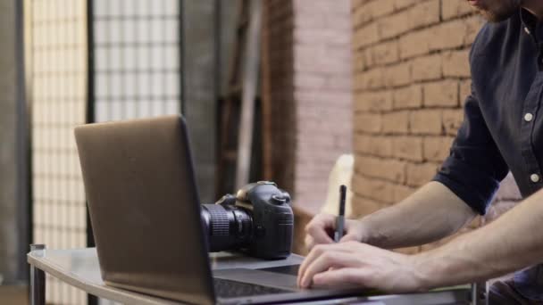 Gesneden mannelijke fotograaf maakt gebruik van een grafische tablet. — Stockvideo