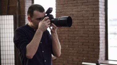 A young male photographer is photographing a model.