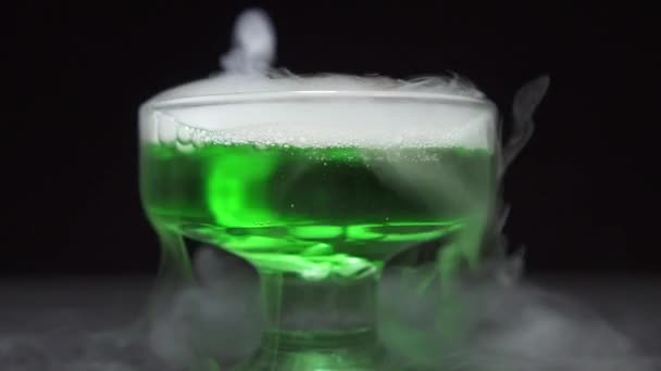 Potion magique est brassée dans un bol en verre sur un fond noir. — Video