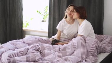 Genç bir lezbiyen çift sabah yatakta sarılıyor..