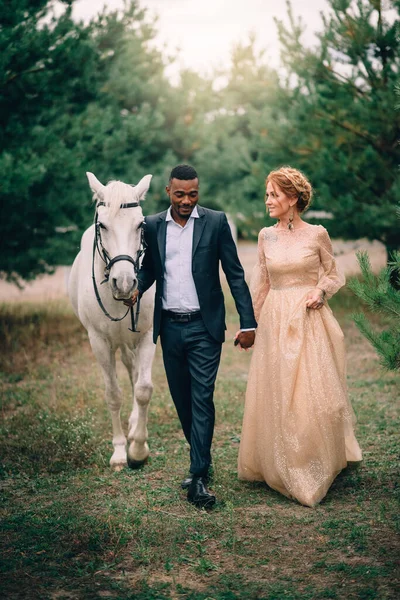 Joyeux couple marchant ensemble sur un ranch avec des chevaux — Photo