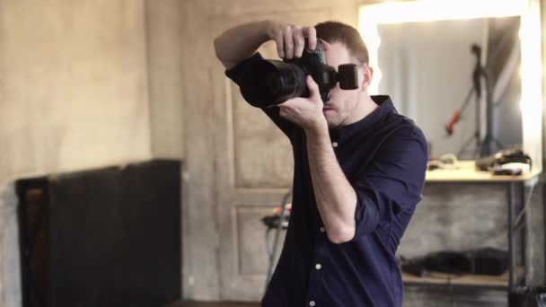 Un joven fotógrafo masculino está fotografiando a una modelo en el estudio. — Vídeo de stock