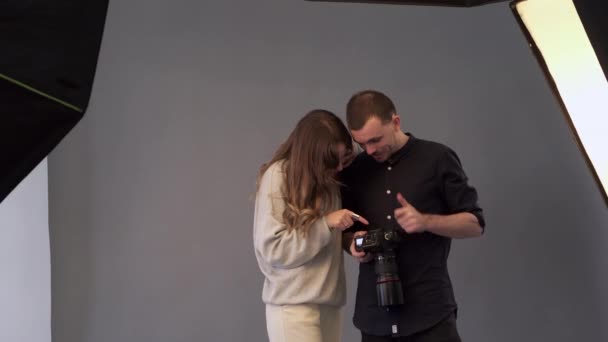 Fotógrafo e modelo estão assistindo imagens capturadas . — Vídeo de Stock