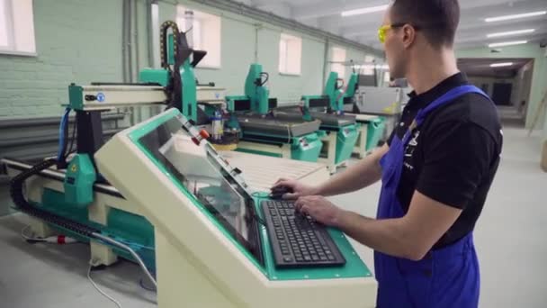 Operatör CNC makinesinin çalışmasını kontrol eder. — Stok video