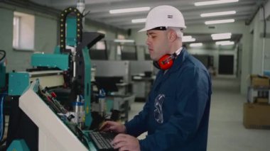 Bir fabrika işçisi kontrol panelinde duruyor..