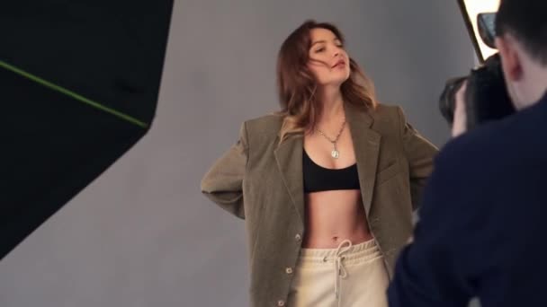 Ženský model pózuje pro mužského fotografa. — Stock video