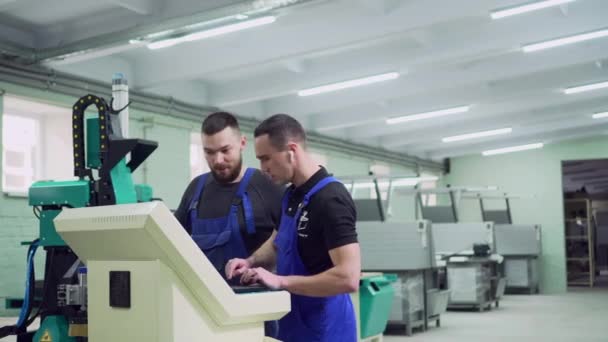 Mentor utbildar en praktikant i en fabrik. — Stockvideo